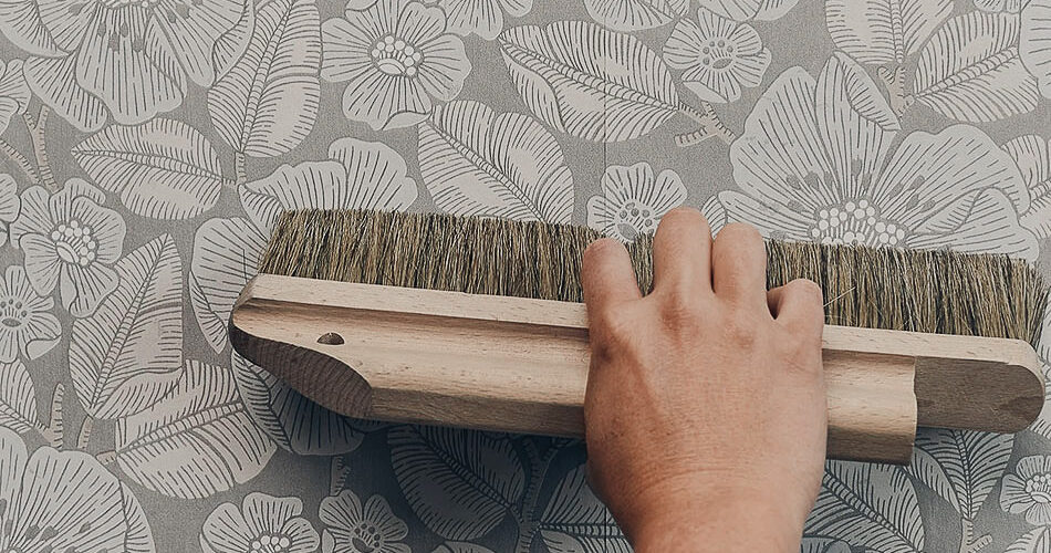 Alisando papel pintado floral con cepillo de empapelar
